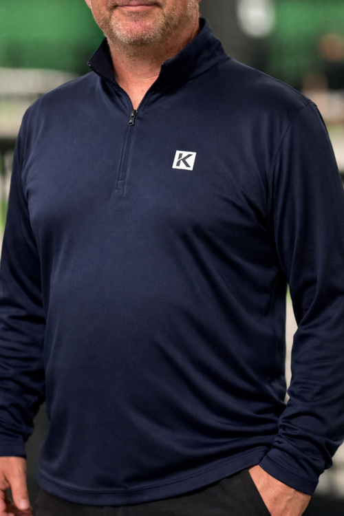 Man wearing a navy long-sleeve shirt with a logo on a blurred background